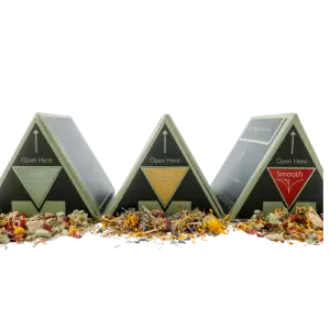 The Ritual Kit by Botanical Embers Co. — Fresh, Classic and Smooth herbal smoking blend triangle boxes displayed together with loose dried botanicals and rose petals