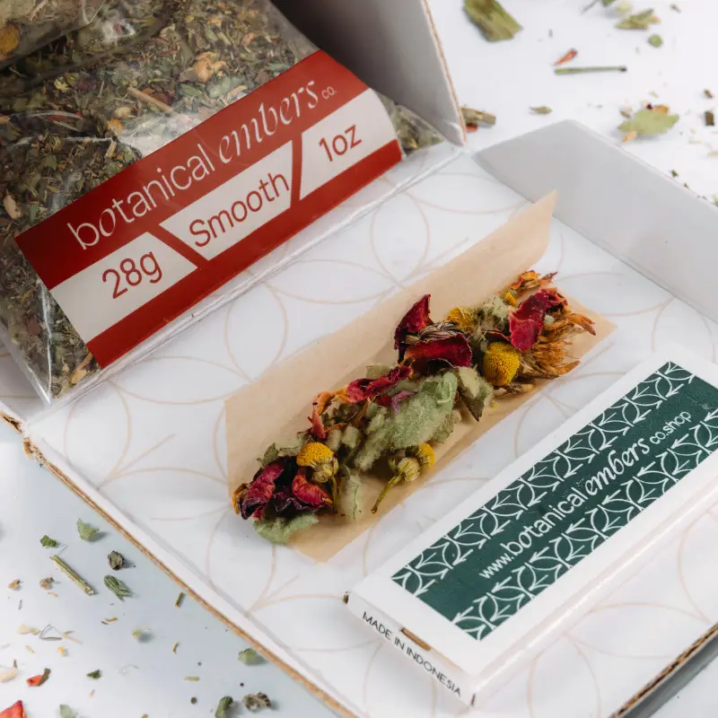Botanical Embers Co. Smooth Blend 28g open triangle box with loose dried botanicals, rose petals and chamomile flowers displayed on rolling papers
